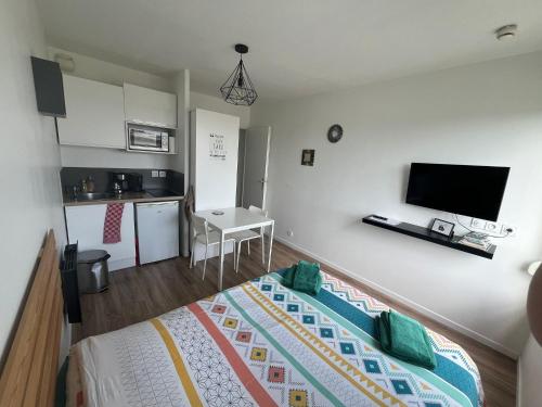 une petite chambre avec un lit et une cuisine dans l'établissement Studio 306 - Gare - Arena - centre Reims, à Reims