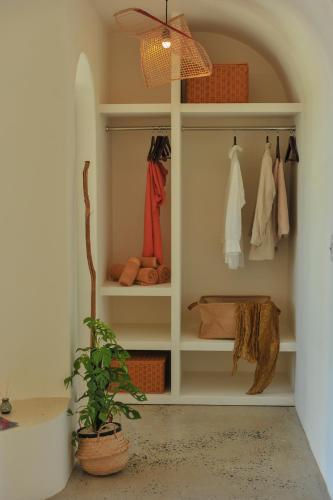 a closet with white shelves and a potted plant at Camfusion House in Hoi An