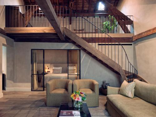 a living room with a staircase and a bed at Botanic Sanctuary Antwerp - The Leading Hotels of the World in Antwerp