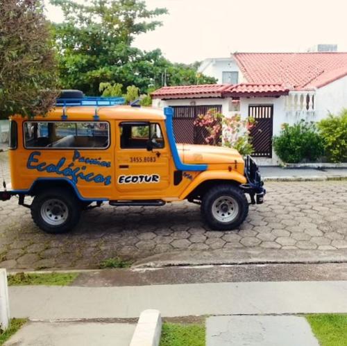 an orange truck parked in a parking lot at Hotel Xapuri in Peruíbe