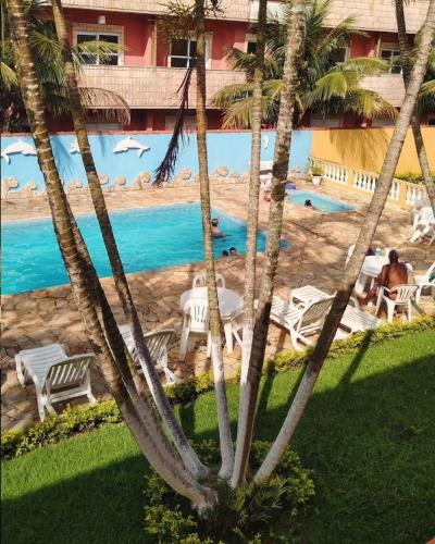 a view of a resort with palm trees and a pool at Hotel Xapuri in Peruíbe