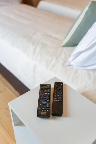 two remote controls sitting on top of a white table at Manoir du Moulin in Berloz
