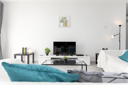 Una sala de estar con un sofá y un televisor. en Casa Vista Bermeja, en Tinajo