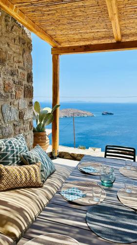 a table with plates on it sitting on a patio at Serene Shore Serifos in Alona