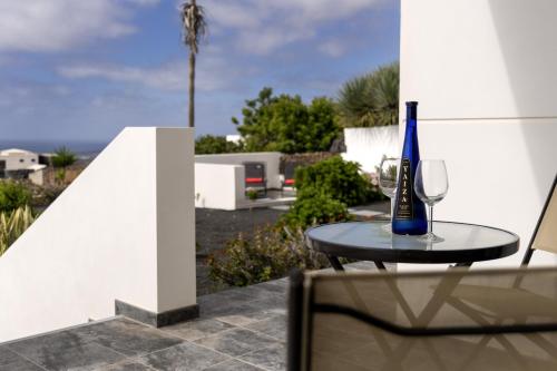 a bottle of wine sitting on a table with a glass at Casa Vista Bermeja in Tinajo