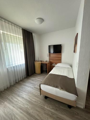 a hotel room with a bed and a television at Hotel Schlangenbader Hof in Schlangenbad
