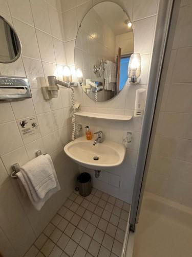 a small bathroom with a sink and a mirror at Hotel Schlangenbader Hof in Schlangenbad