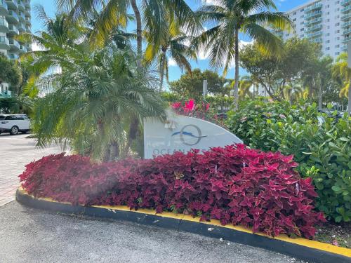 a sign in a bed of purple flowers at Condominium Sunny Isles Ocean Reserve in Sunny Isles Beach