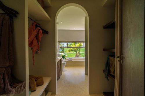 a hallway with an archway in a room with a window at Camfusion House in Hoi An