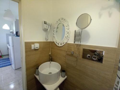 a bathroom with a toilet and a mirror on the wall at TOLUAMMARE Sicily in Santa Maria Del Focallo