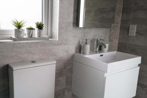 a white bathroom with a sink and a toilet at Arrochar View in Langbank