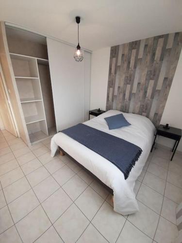 une chambre avec un lit avec une couverture bleue dans l'établissement Le Maraîcher avec terrasse, wifi, parking gratuit, à Belfort