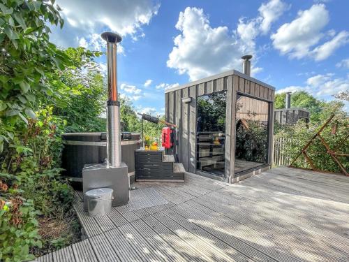 a wooden deck with a greenhouse and a hot tub at traumHaff Lotsen Romantik-Ostsee mit Kamin, privates NORDICSPA und Boot in Rieth