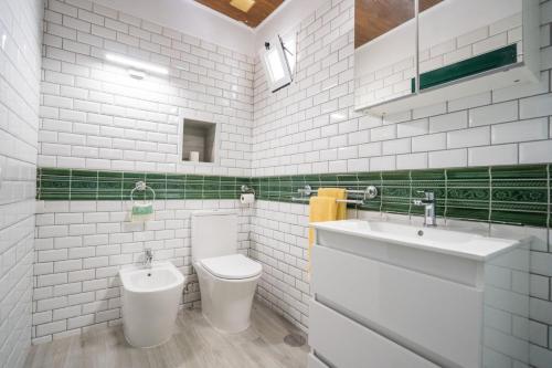 a white bathroom with a toilet and a sink at Casa Rural da Eva in Santa Cruz de Tenerife