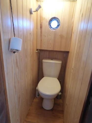 a small bathroom with a toilet in a wooden wall at Domaine du Balbuzard in Condat-en-Combraille