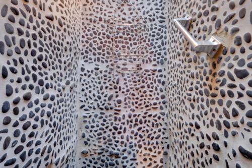 a bathroom with a metal wall with a shower at Adobe Studio 2 Blocks to Dtwn Santa Fe Plaza! in Santa Fe