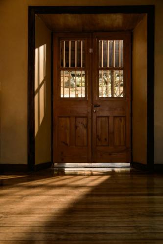 an empty room with a wooden door and windows at Solar Madariaga Hotel in Vicuña