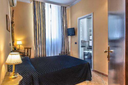 a hotel room with a bed and a window at Hotel Caracciolo in Rome