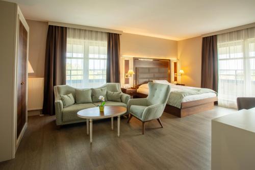a hotel room with a bed and a table and chairs at City Hotel Frankfurt Bad Vilbel in Bad Vilbel