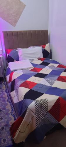 a bed with a colorful quilt on it in a room at Home Away Apartment in Abu Dhabi