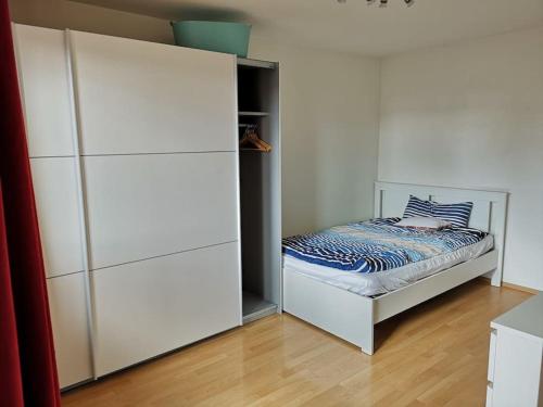 a white bedroom with a bed and a closet at Furnished Apt near Daimler, business & family in Sindelfingen
