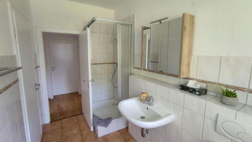 a white bathroom with a sink and a mirror at Ferienwohnung am Kloster in Duderstadt
