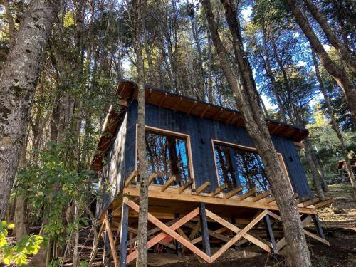 a blue tree house in the woods at Tiny house sobre el lago nahuel huapi in San Carlos de Bariloche