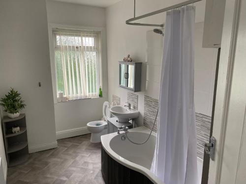 a bathroom with a tub and a sink and a toilet at Marvellous Room 1 in Stoke on Trent