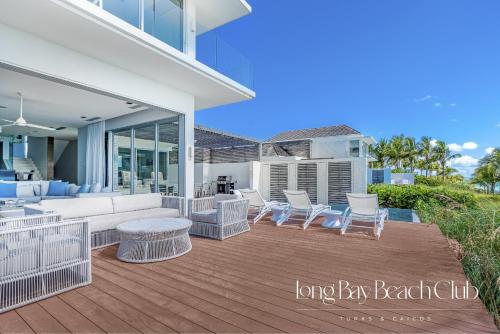 a patio with a couch and chairs on a deck at Long Bay Beach Club in Long Bay Hills