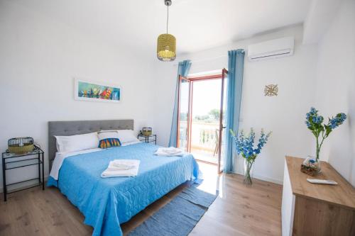 a bedroom with a bed with a blue blanket at B&B Casa Cosmano in Brancaleone Marina