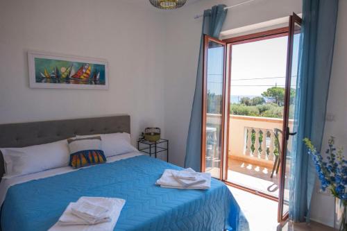 a bedroom with a blue bed and a balcony at B&B Casa Cosmano in Brancaleone Marina
