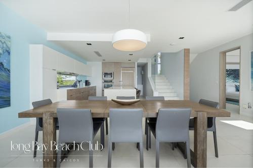 a dining room and kitchen with a wooden table and chairs at Long Bay Beach Club in Long Bay Hills