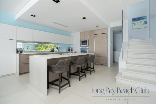 a kitchen with a large bar with stools at Long Bay Beach Club in Long Bay Hills