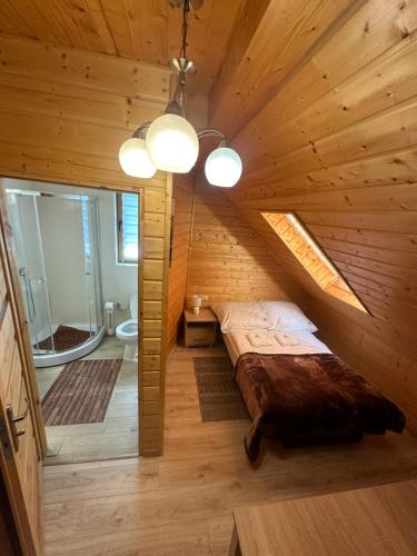 a bedroom with a bed in a wooden cabin at Domki nad potokiem in Wetlina