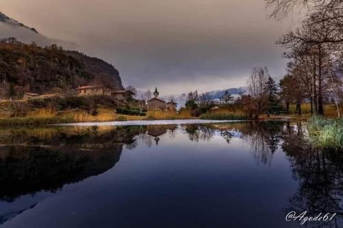 a view of a lake with a church in the background at Casa vacanze "INCANTO DEL LAGO" in Corna