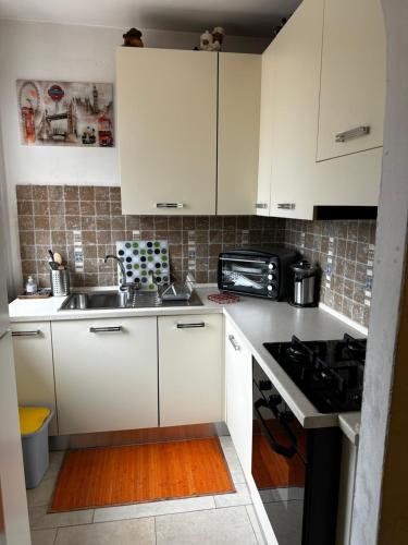 a small kitchen with white cabinets and a sink at Casa vacanze "INCANTO DEL LAGO" in Corna