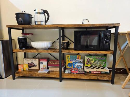 a shelf with a microwave and books on it at Joenice Lipa Staycation in Lipa