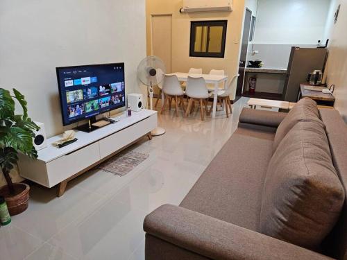 a living room with a couch and a flat screen tv at Joenice Lipa Staycation in Lipa