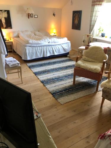 a bedroom with a bed and a living room at Långhedgården Bed & Breakfast in Alfta