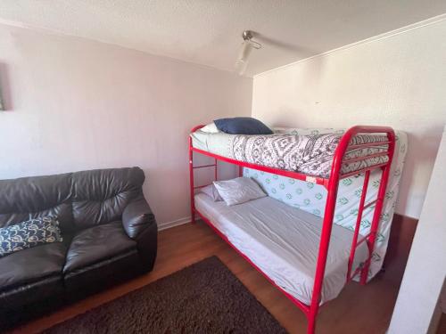 a room with a bunk bed and a couch at Icono central frente mall plaza 2 dormitorios in Antofagasta