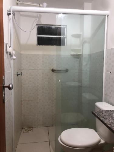a bathroom with a glass shower with a toilet at Flat Shopping Amarração N - 129 in Luis Correia