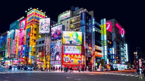 a busy city street at night with neon signs at Alo BnB 10 - Near AKIHABARA, UENO, ASAKUSA, TOKYO SKY TREE - Self check-in in Tokyo