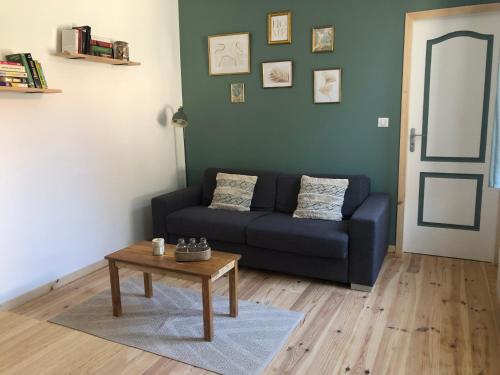 a living room with a blue couch and a table at Charmante petite maison proximité Vichy centre in Vichy