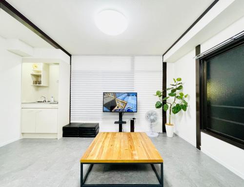 a living room with a table and a tv at Alo BnB 10 - Near AKIHABARA, UENO, ASAKUSA, TOKYO SKY TREE - Self check-in in Tokyo