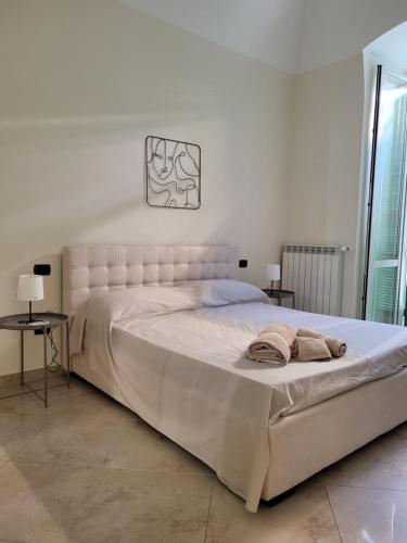 a bedroom with a large white bed with two towels on it at B&B La Botola in Bisceglie