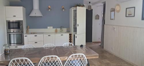 une cuisine avec une table et des chaises dans l'établissement Maison neuve jardin & terrasse, à Lanton