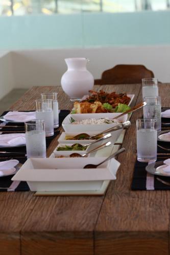 a table with plates of food and glasses of water at Villa Santé by The Serendipity Collection in Kalpitiya