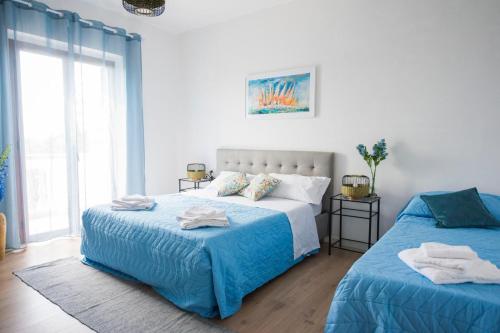 a bedroom with two beds with blue sheets at B&B Casa Cosmano in Brancaleone Marina