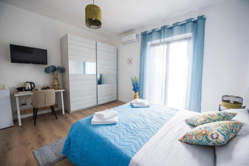 a bedroom with a blue and white bed and a window at B&B Casa Cosmano in Brancaleone Marina