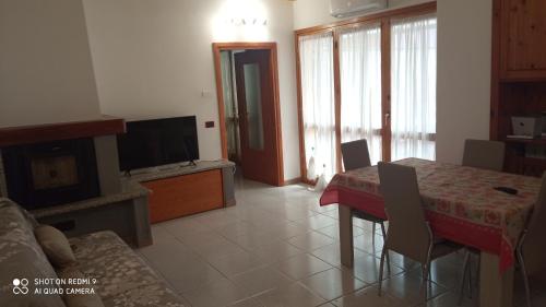 a living room with a table and a television at Casa Vanda in Luino